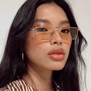 Peach colored sunglasses with gold tone frame